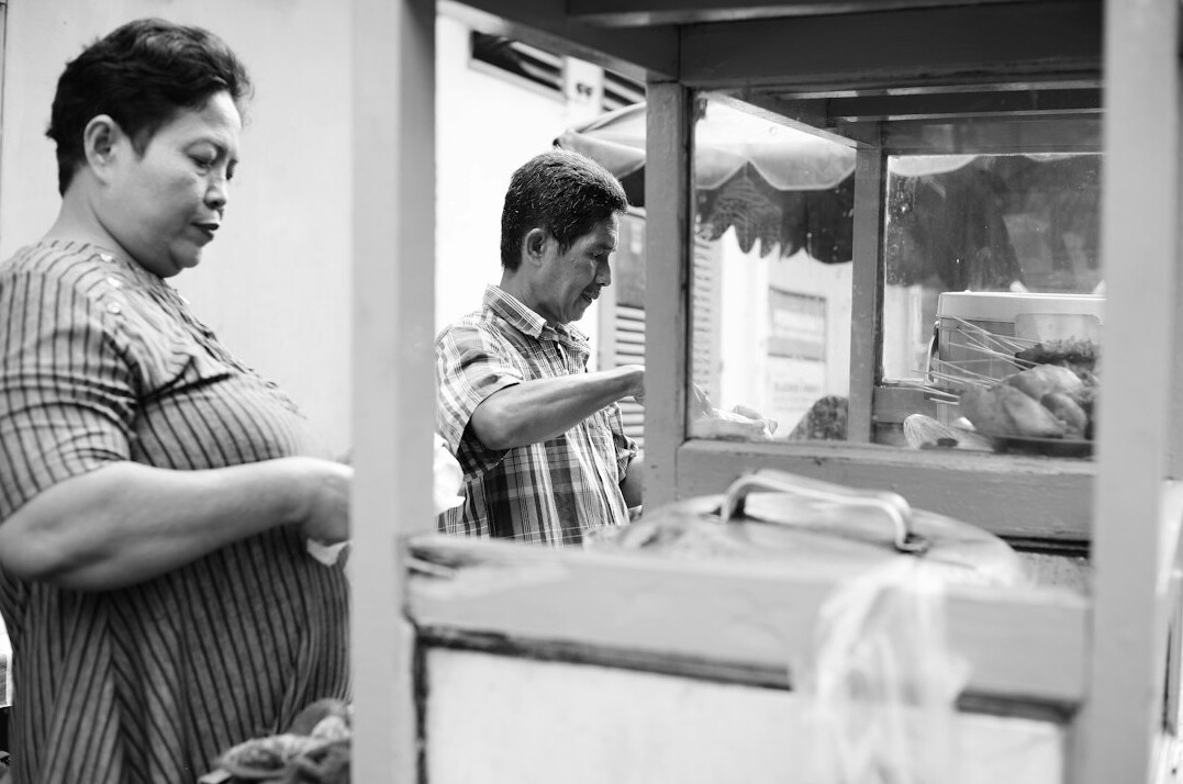 Two colleagues verifying documents and cross checking information on a screen
