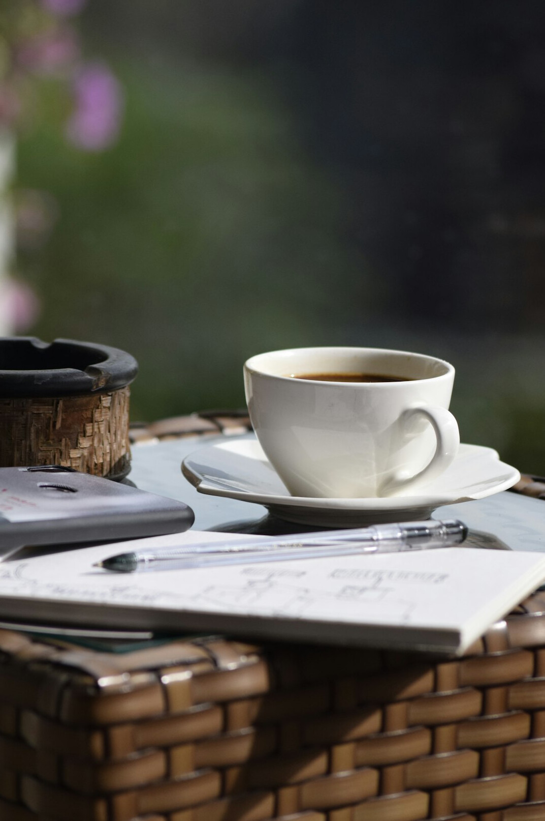 Close up of a journalist writing notes next to a laptop and coffee